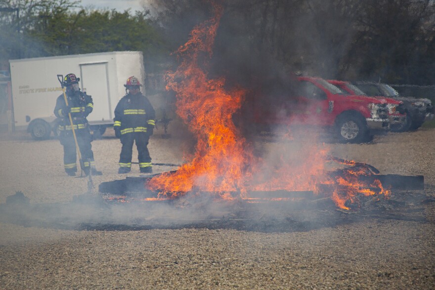 Boise firefighters look on at the collapsed ruins of the poorly prepared demonstration home. 