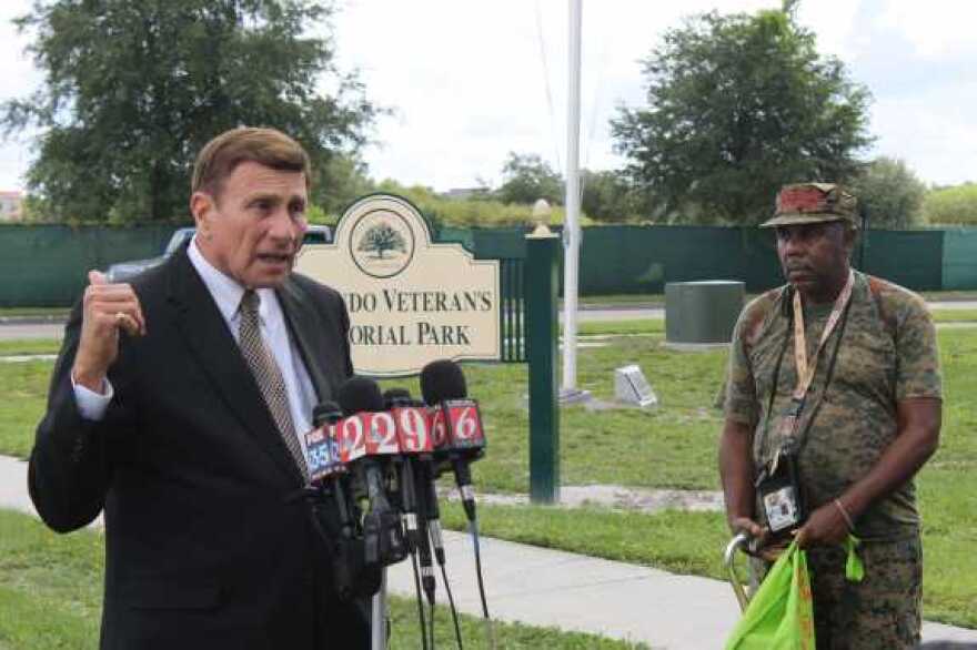 John Mica speaks to the media in front of the Lake Baldwin VA facility as US Army veteran Michael Durieux looks on. Photo: Matthew Peddie, WMFE