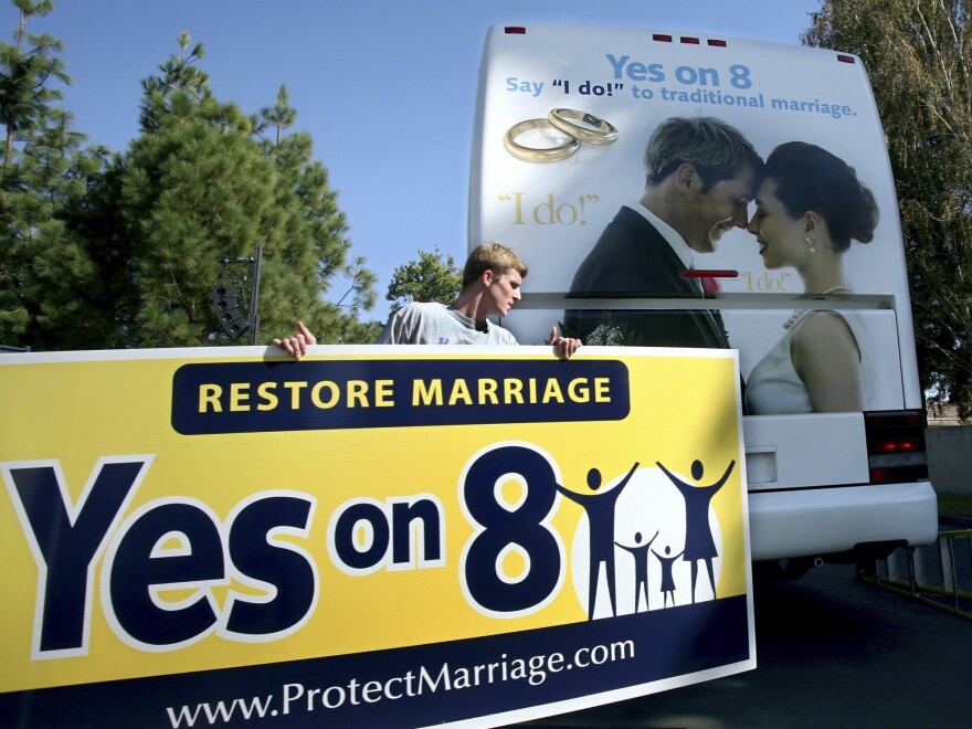 Richie Beanan of Los Angeles puts a sign on a bus in support of California's Proposition 8 gay marriage ban after a rally in Sacramento in October 2008.