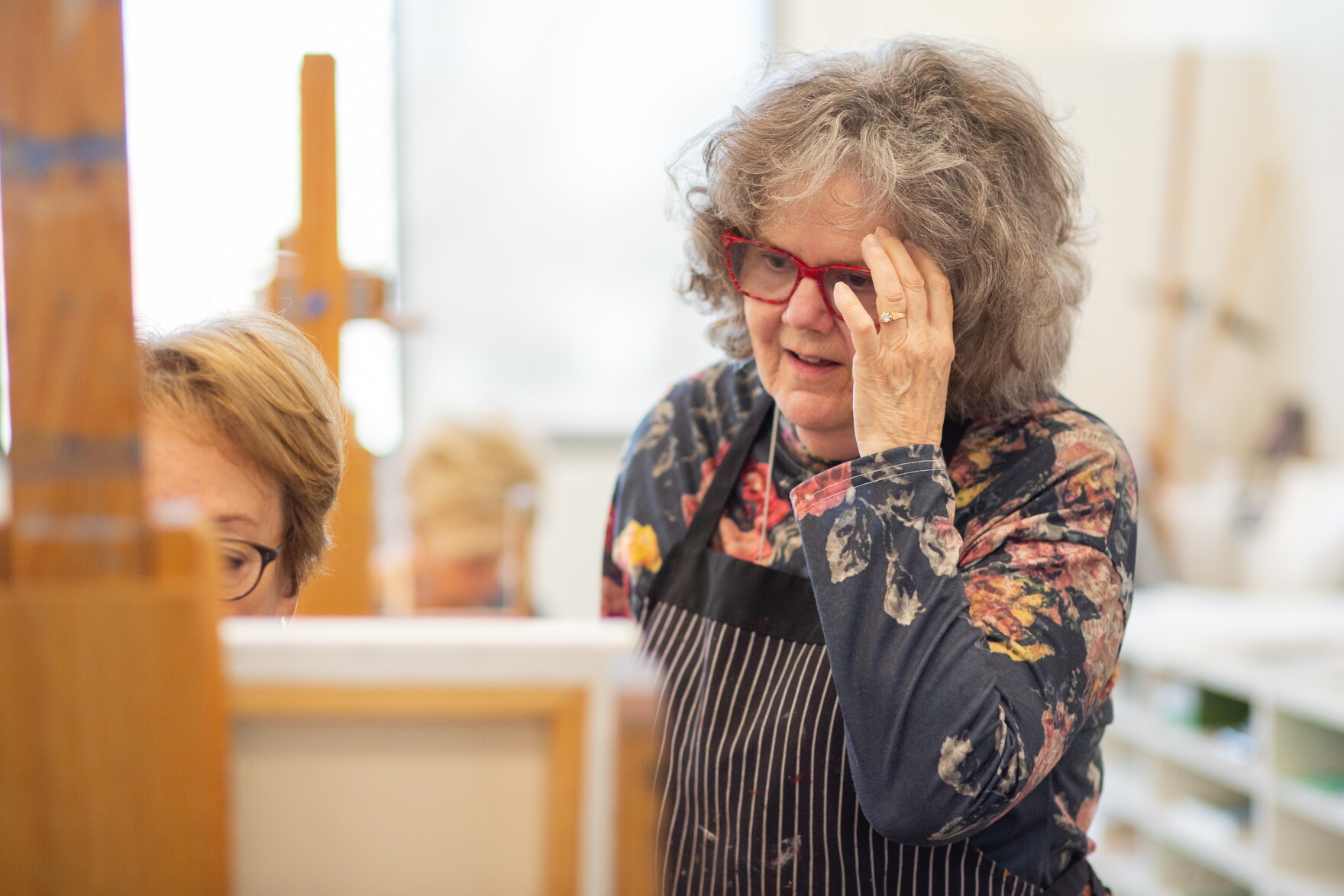 Mary Binford Miller offers feedback for a fellow Wichita Women Artists member during a painting class at Mark Arts.