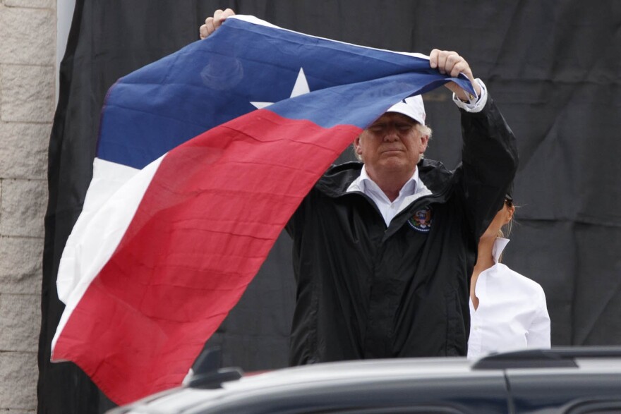 President Donald Trump holds up a Texas flag after speaking with supporters outside Firehouse 5  in Corpus Christi, Texas, Tuesday, Aug. 29, 2017. (Evan Vucci/AP)