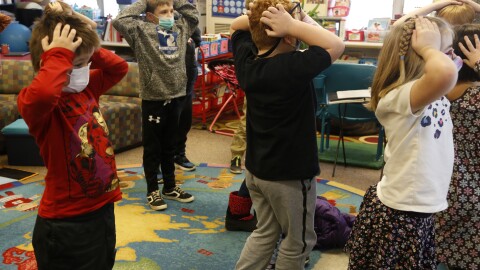 Second-graders hold their heads as they talk about "thoughts" and how they compare with "feelings" and resulting "actions," at Paw Paw Elementary School earlier this month, in Paw Paw, Mich.