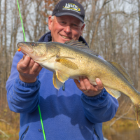 A man holds a walleye on a Minnesota lake measuring 28 inches