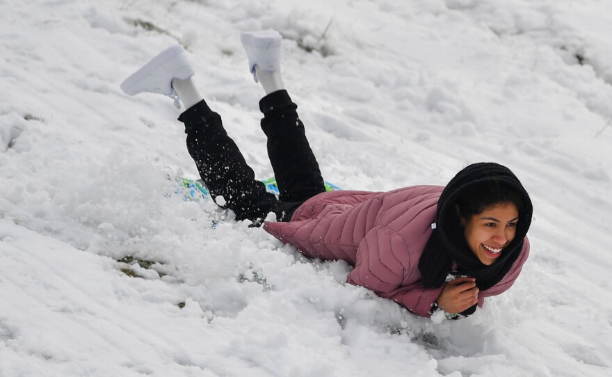 Elianny Hernandez sleds down a hill in Kirby Park.