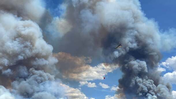 A helicopter carrying a water bucket to fight the Wide Mouth 2 Fire in Millard County.