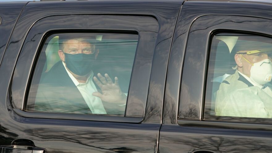 Dr. James Phillips is no longer working at Walter Reed National Military Medical Center, months after criticizing President Trump's flouting of coronavirus safety guidelines. Here, Trump waves to supporters from an SUV in October as he was driven outside the facility in Bethesda, Md.