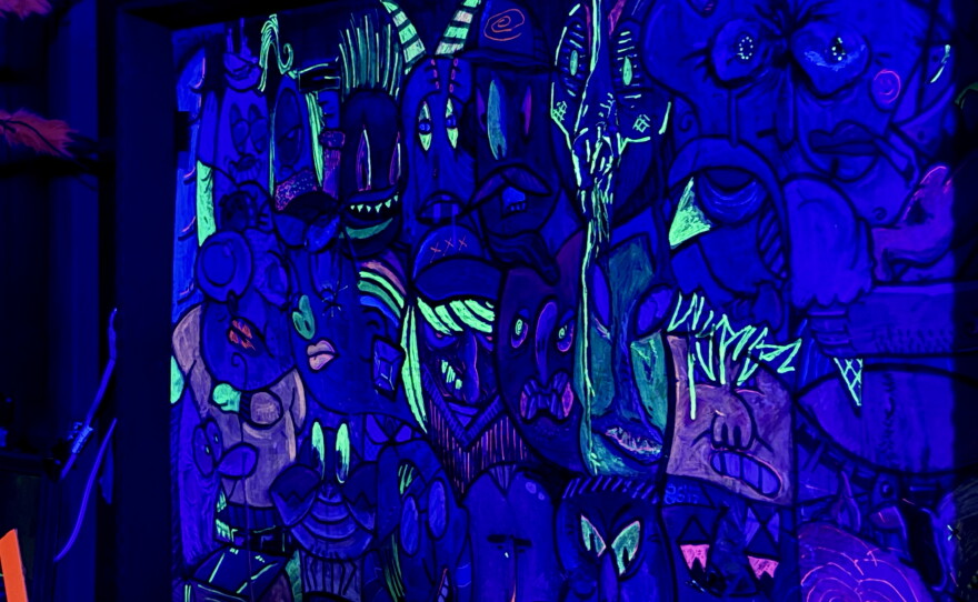 A wall with painted faces. 