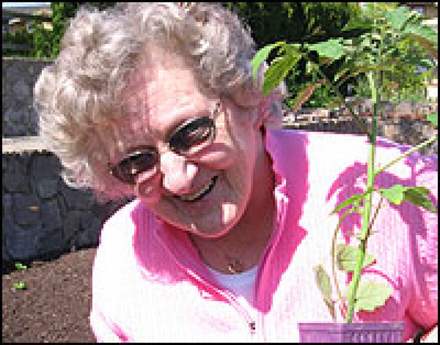 Resident Dorothy Kimmeland helps plant tomatoes. Oatfield Estates' tracking system gives her daughter a better idea of what kind of care she's receiving, and what her day is like.