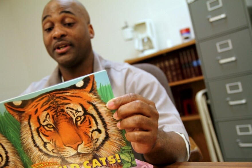 Missouri inmate Callion Barnes reads a storybook about tigers.