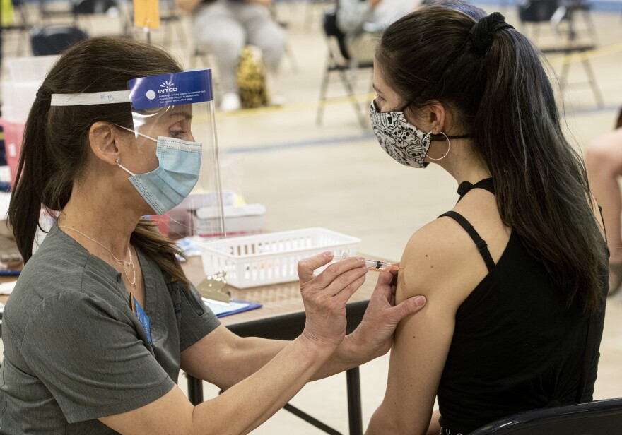 Kent State University student Regan Raeth of Hudson, Ohio, has her COVID-19 vaccination administered by Kent State nurse Kristen Barath in Kent, Ohio. 