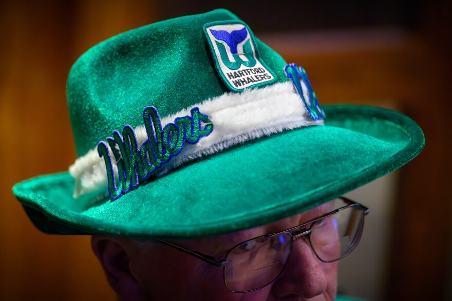 Windsor Locks, Ct. — April 13, 2026 — Hartford Whalers Booster Club members David Laczynski wears a Whalers chat during a meeting of the club on April 13, 2026, at Bobby V’s sports bar on the 29th anniversary of the last Hartford Whalers. (Mark Mirko/Connecticut Public)