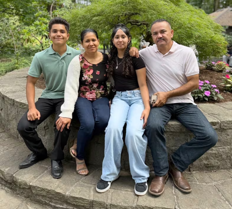 Four people sit close together and pose for a portrait.