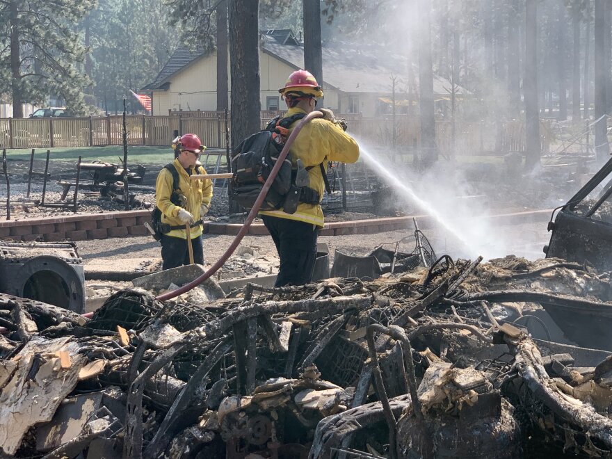  Two firefighters stamping out fire in the Lake Shastina community from the Mill Fire