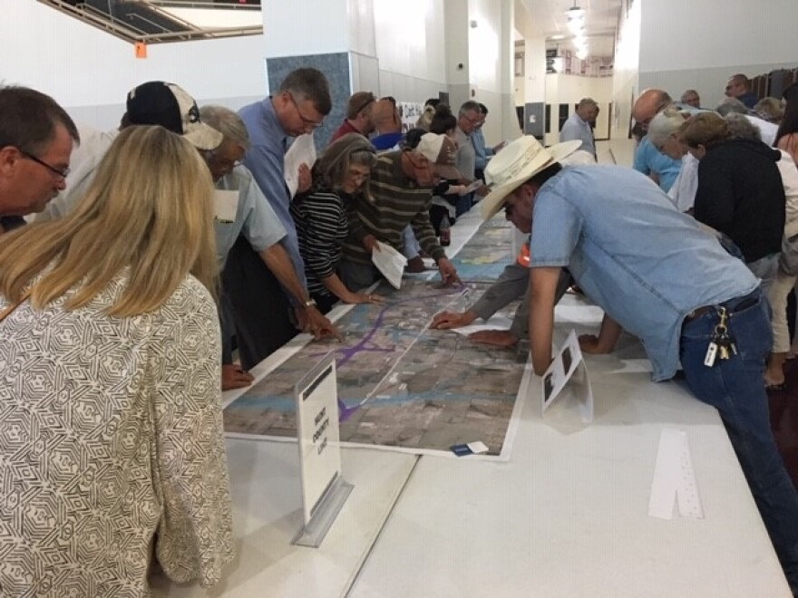 People study graphics depicting proposed changes to U.S. Highway 380 at a public meeting in Princeton on May 9.