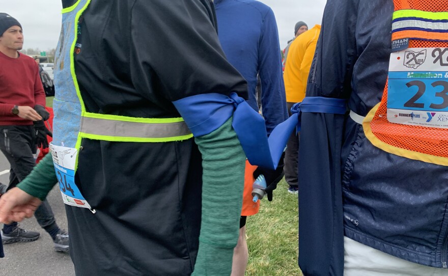 The pair run in tandem–bound arm to arm by a thick, plastic exercise band. Moran uses it to communicate with Centeno and help keep him safe.