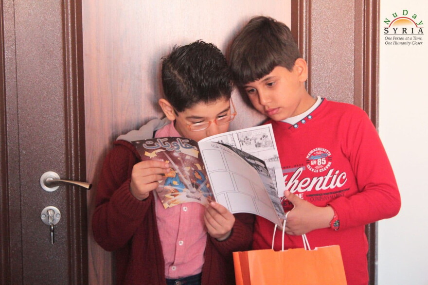 Syrian refugee children read the free comic book "Haawiyat" at a refugee camp in Turkey. (Courtesy NuDay Syria)