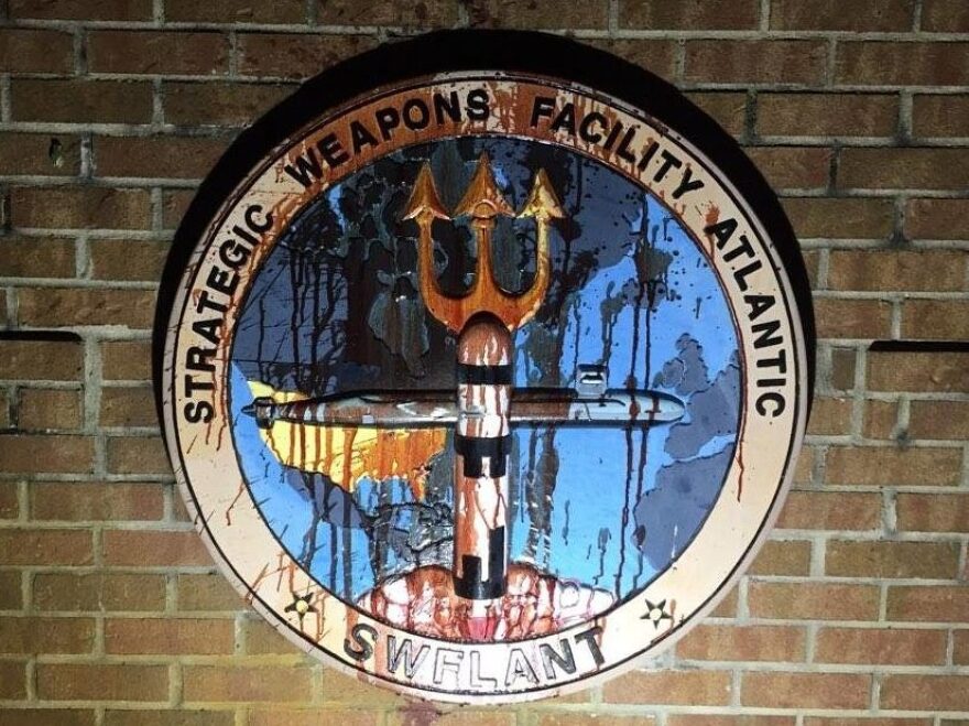 The protesters poured bottles of their own blood on the naval base shield at Kings Bay.