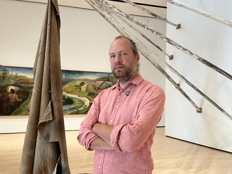 Steven Bridges in the Broad Art Museum with two works behind him
