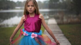 Lily Tallerico, 9, poses outside of her Palatka house in one of the new gowns in her fashion line that will debut Saturday at the Fashion for Freedom runway show. This dress, inspired by the queen of all colors, is Lily’s favorite out of her line of eight dresses.