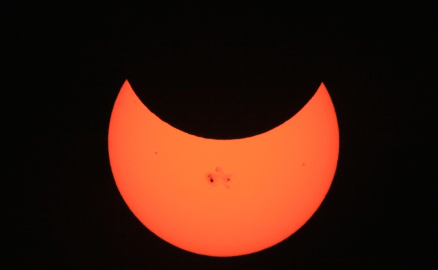 Image of the partial solar eclipse on October 23, 2014. The darkened spots on the sun are "sun spots," regions of cooler surface temperature.