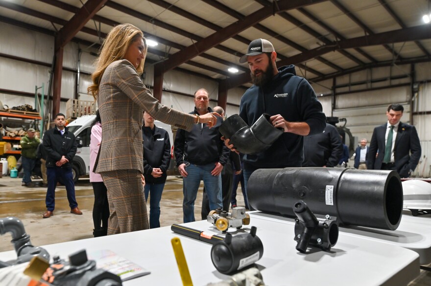 U.S. Small Business Administrator Kelly Loeffler learns about fittings and parts used by Kriger Pipeline from Joel Kriger during a tour of his family's business in Dickson City.