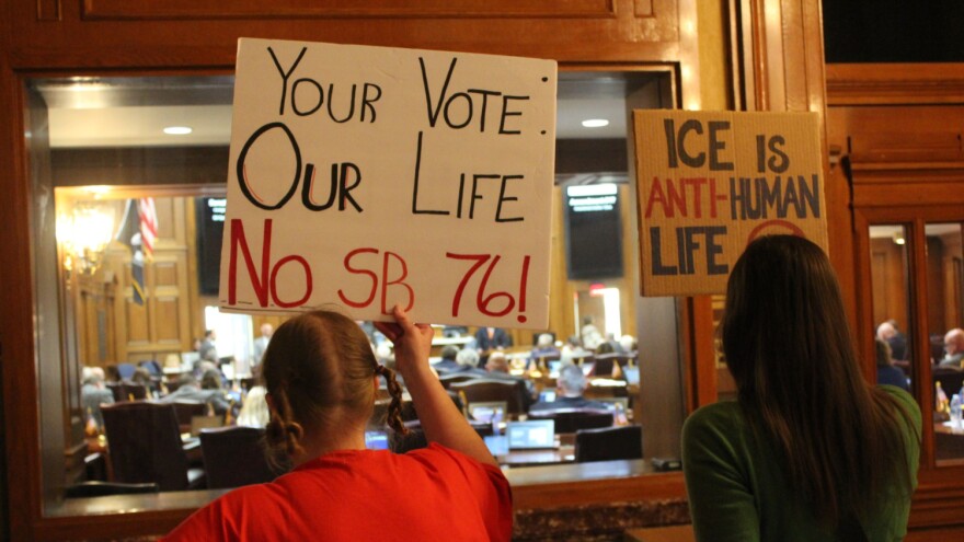 Protesters Leah Kramer and Meredith Deem hold signs at the Indiana Statehouse on Tuesday, February 10, 2026.