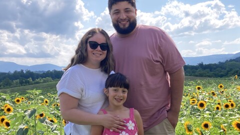 Ann Amairi joins her husband and daughter for a sunny family photo.