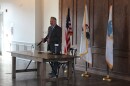 Congressman Eric Sorensen hosts a town hall in Peoria Ill. Stands in front of three flags. American Illinois and Peoria. 