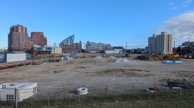 Undeveloped lots contain piles of dirt and construction equipment.