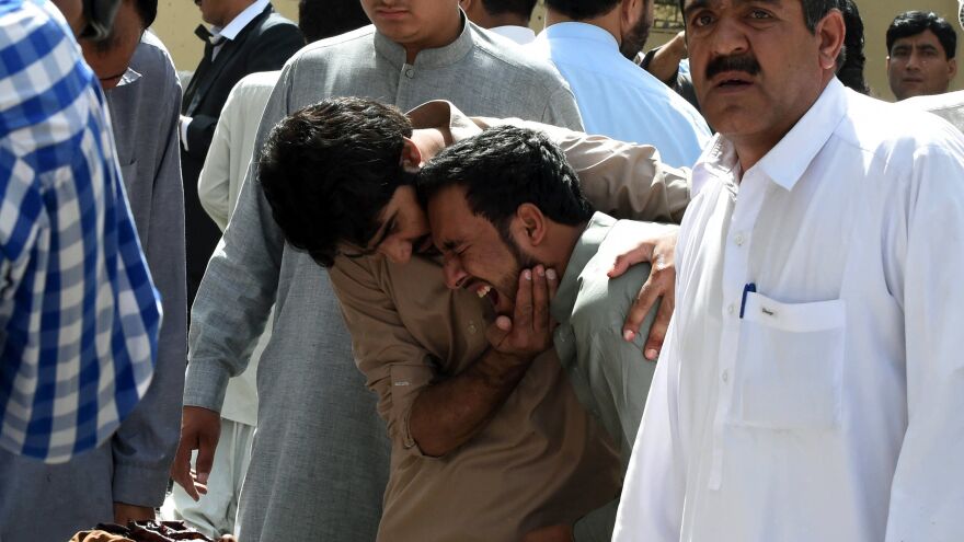 Pakistani journalists grieve over the body of a news cameraman after an explosion at a government hospital in Quetta on Monday.