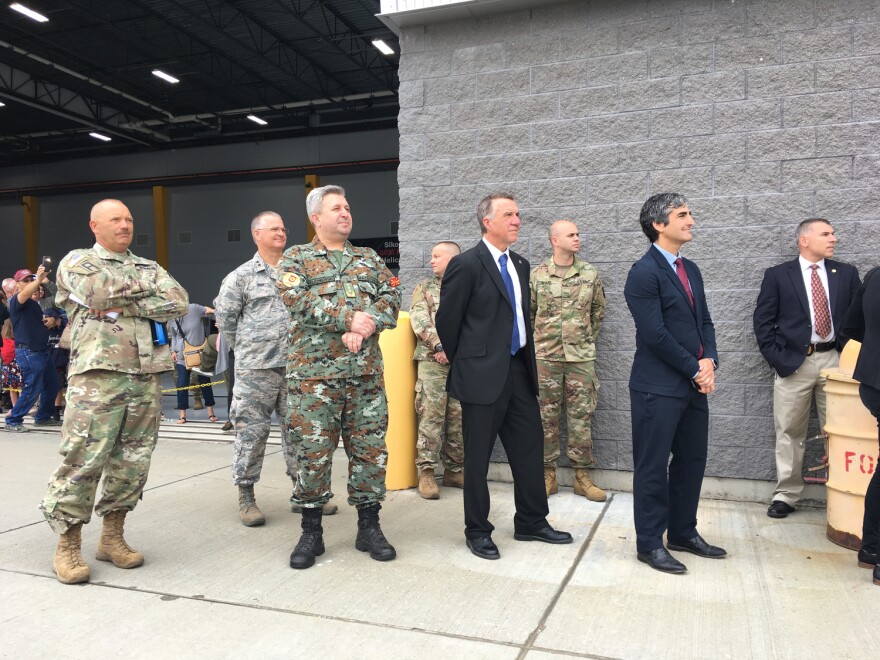 Gov. Phil Scott and Burlington Mayor Miro Weinberger watch as six Blackhawk helicopters take off. More than 60 members of the Vermont National Guard are preparing for deployment overseas. 