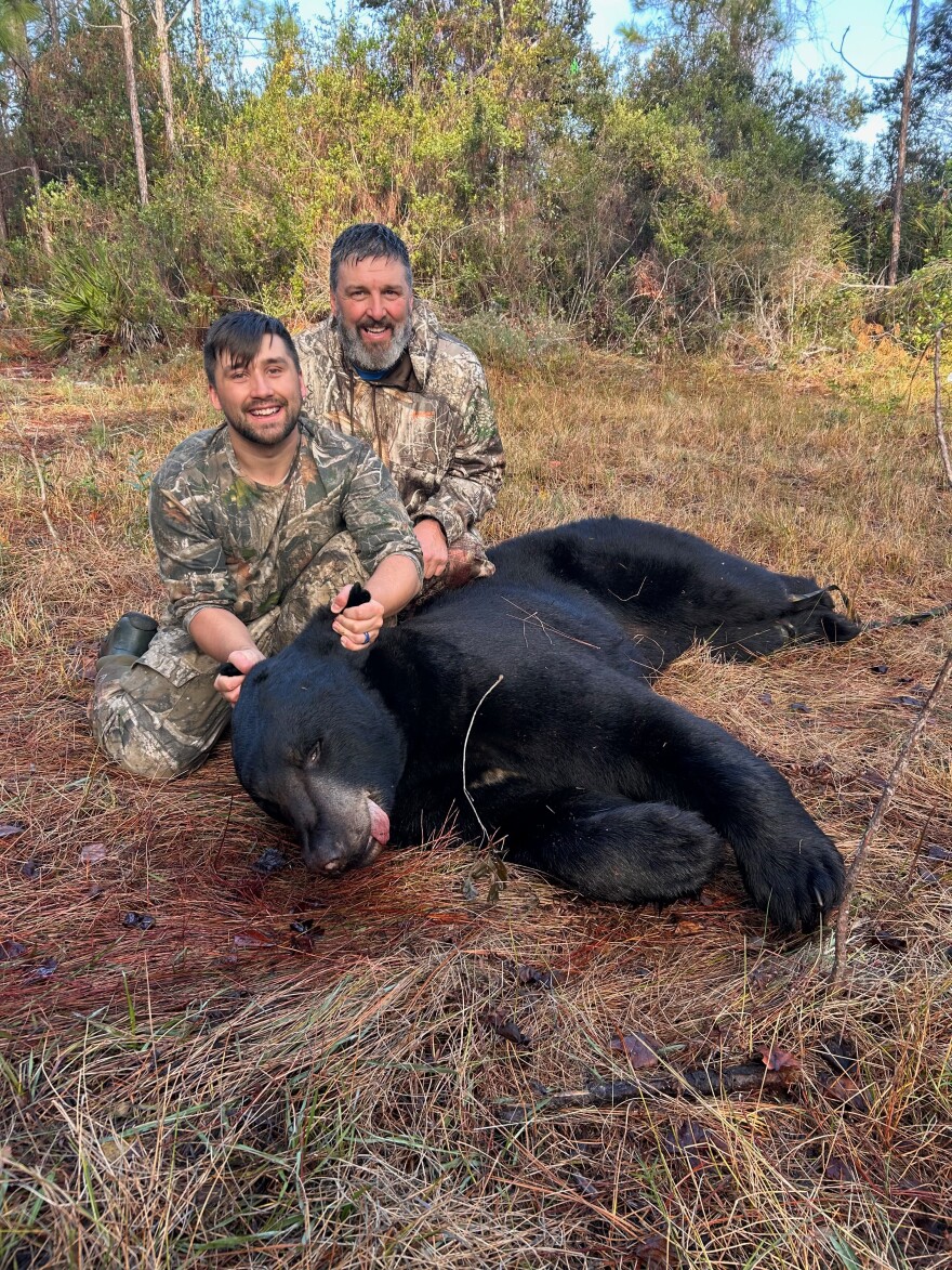 Jeff Nemeth, 57, and his son Rees Nemeth, 27, pose with an 8-foot-3 Florida black bear they harvested Dec. 9, 2025, in Eastpoint, Fla. Jeff Nemeth traveled four hours north from his home in Inverness to hunt the bear, which he said weighed 503 pounds once cleaned. 