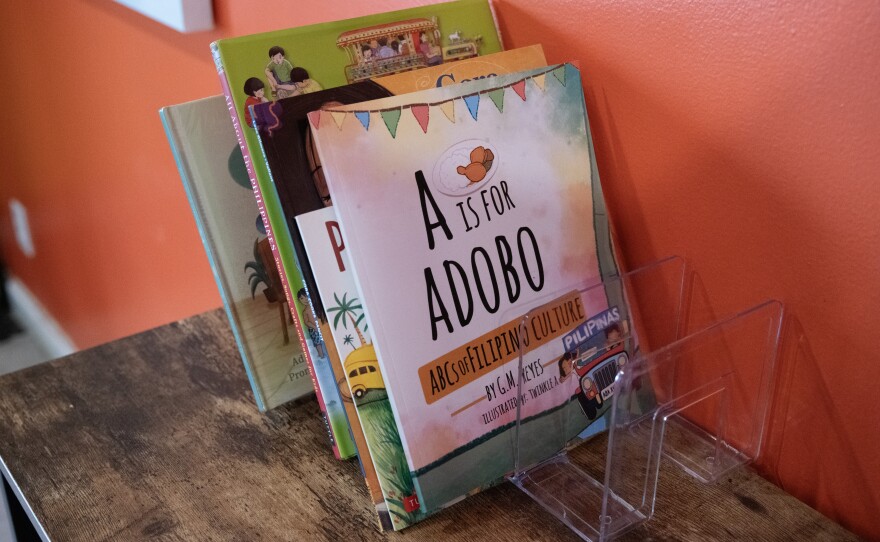 A small library of children’s books sits on the shelf in the Adobo Boy dining room, including “A is for Adobo,” “Cora Cooks Pancit,” and “Pan de Sal Saves the Day.”