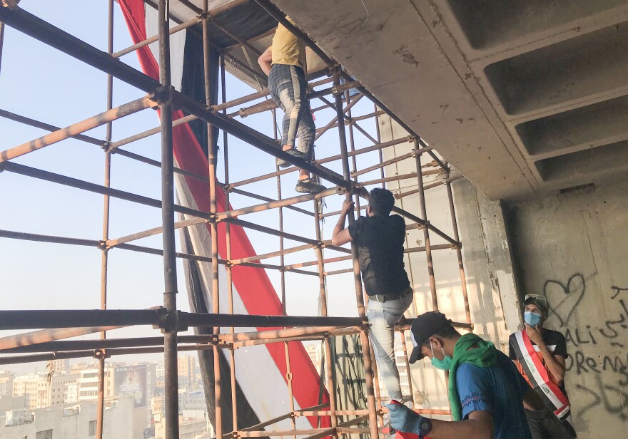 Protestors climb scaffolding to reach the top of a Baghdad landmark known as the "Turkish restaurant building." It has no electricity, elevators or even walls. The building looks over Tahrir Square and has been occupied by protesters to prevent security forces from using it to shoot at demonstrators below.