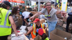 Lisa Galindez calls on other volunteers to help pack baby items at the Global Empowerment Mission Venezuela relief donation site Tuesday, June 30, 2026, in Doral, Fla.