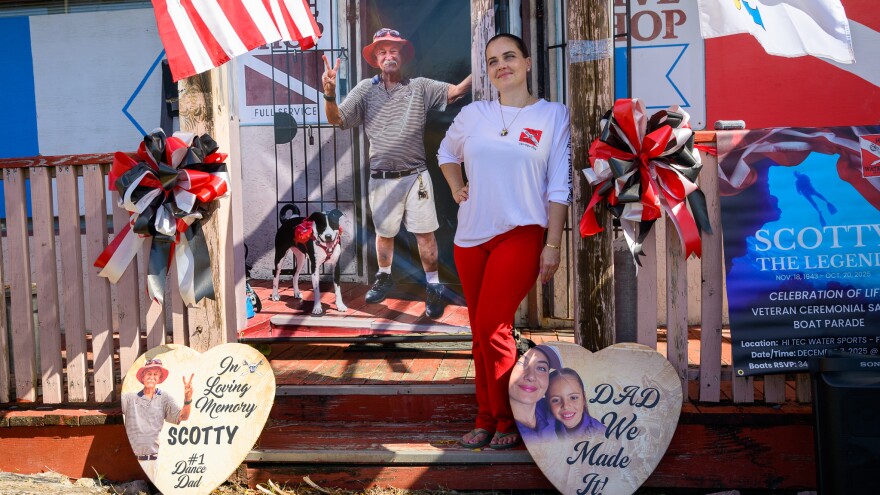 Pictured: Lea Scott stands beside a memorial display honoring her father, Richard “Scotty” Scott.