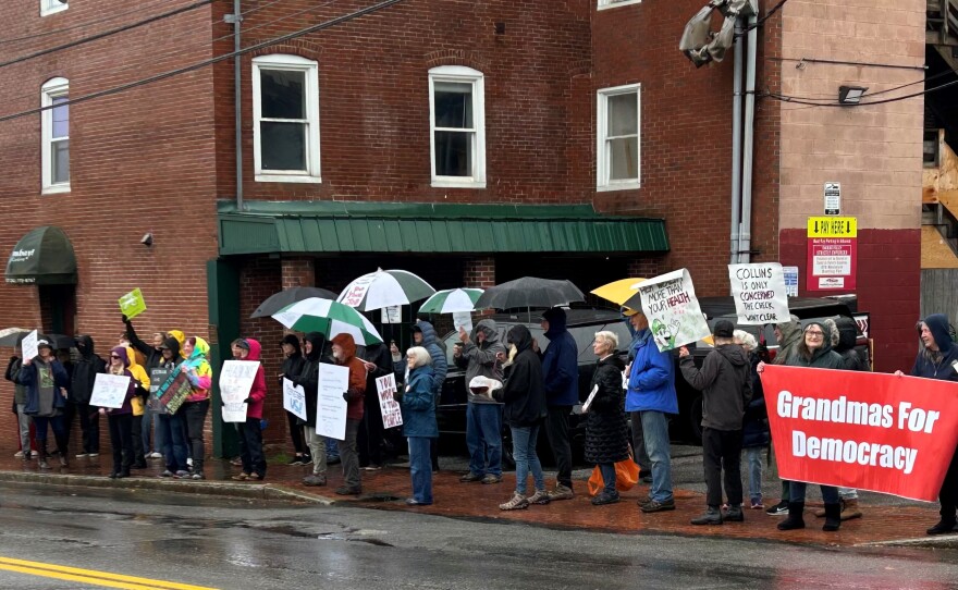 Protestors outside Senator Angus King's office on Pleasant Street in Portland on Monday.