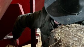 Rancher Lamont Herman checks on repairs he and his son made to a vintage grain grinder