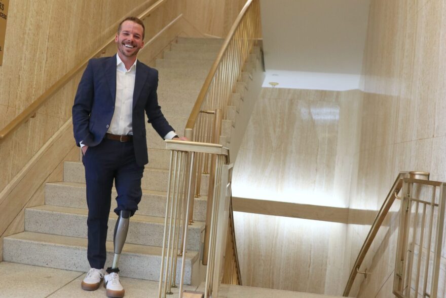 Team USA paratriathlete Kyle Stepp, who lives in Albuquerque, is advocating for New Mexico to expand requirements for health insurance plans to pay for wheelchairs for recreation and exercise. Stepp, a national representative for disability rights group So Every BODY Can Move, appeared at the Roundhouse on Feb. 11, 2026. (Danielle Prokop/ Source NM)