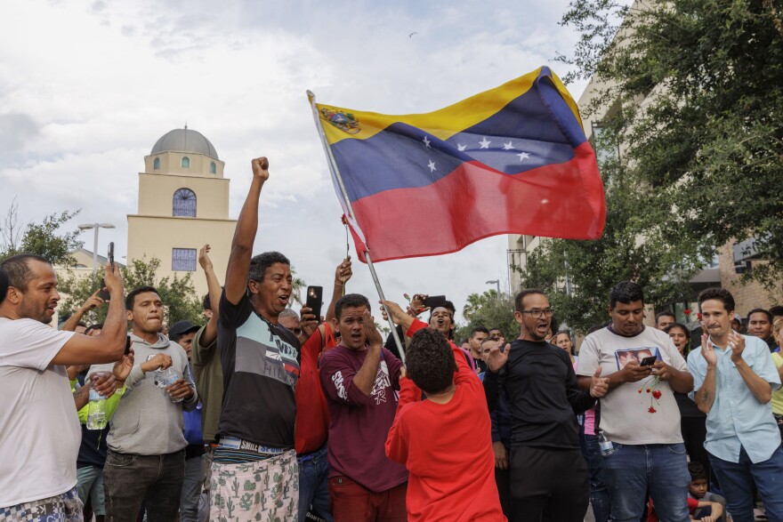 A boy waves the Venezuelan flag last week at a vigil for migrants killed by an SUV on May 7 while waiting at a bus stop in Brownsville, Texas.