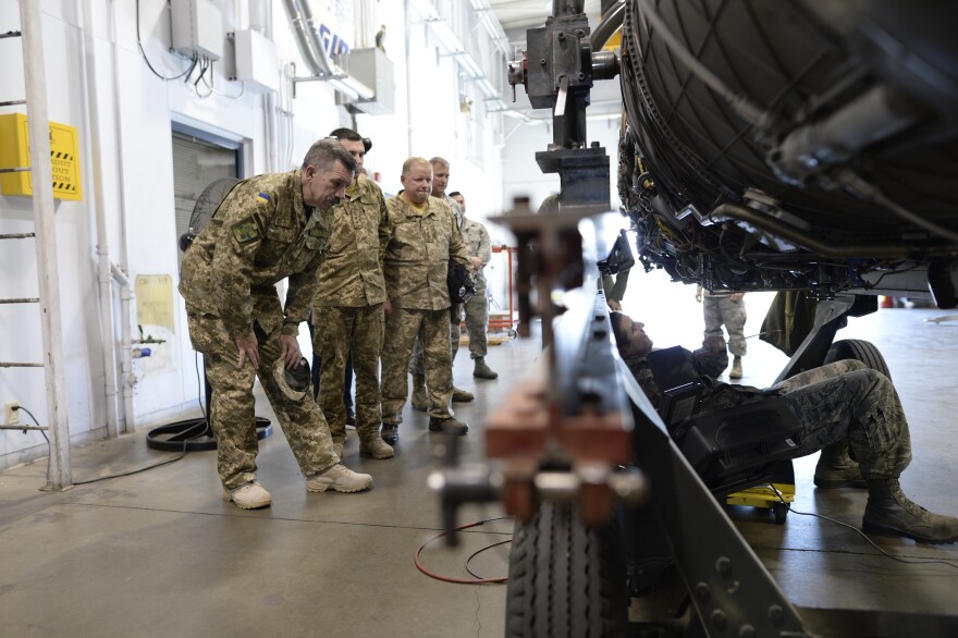 Members of the Ukrainian military watch as a California National Guard Tech. Sgt. Brian Spalliero services a Pratt and Whitney F100-220 jet engine. The Ukrainian delegation was visiting the the 144th Fighter Wing in Fresno, Cal. in 2017.