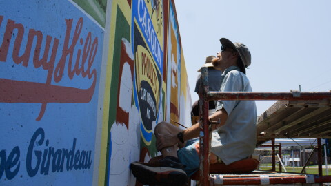 Painter Jess Wells glances at the meticulous work the group is doing along the new Cape Girardeau, Mo., flood wall mural on August 11th.