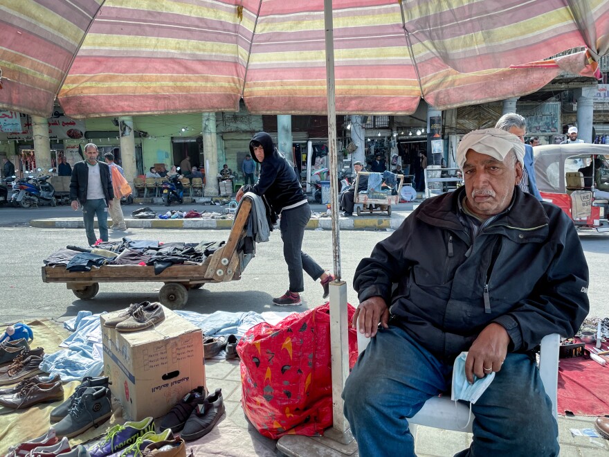 Razak Abdul-Zahra Mubarak, 70, sells used shoes on the street in al Maidan Square in Baghdad. "Each year it's getting hotter and hotter," he says — and even in winter he now needs the shade of an umbrella.