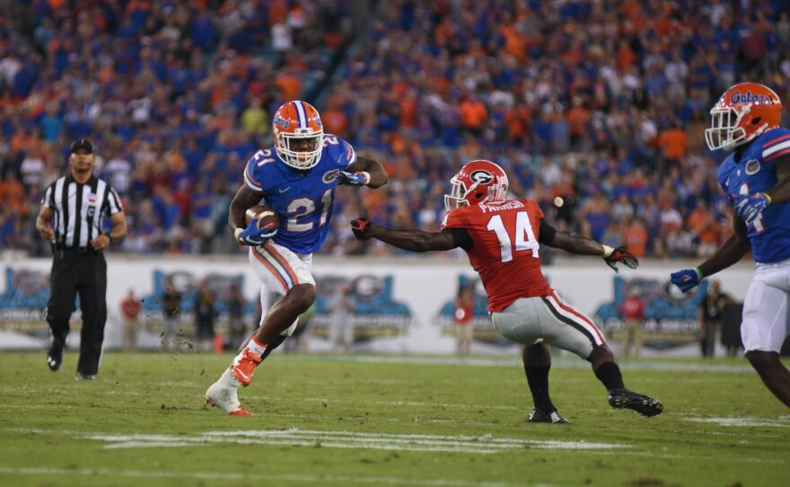 Florida running back Kelvin Taylor (21) makes a quick cut to avoid Georgia cornerback Malkom Parrish (14).