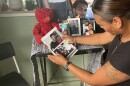  Arlene Garcia holds a photobook full of pictures of her son, Kevin Johnson, at a small memorial on her home's front porch.