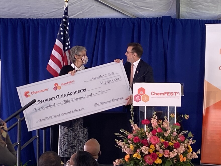 Serviam Girls Academy President Peggy Prevoznik Heins receives a check for ChemFes(T2) investment from Chemours CEO Mark Newman.