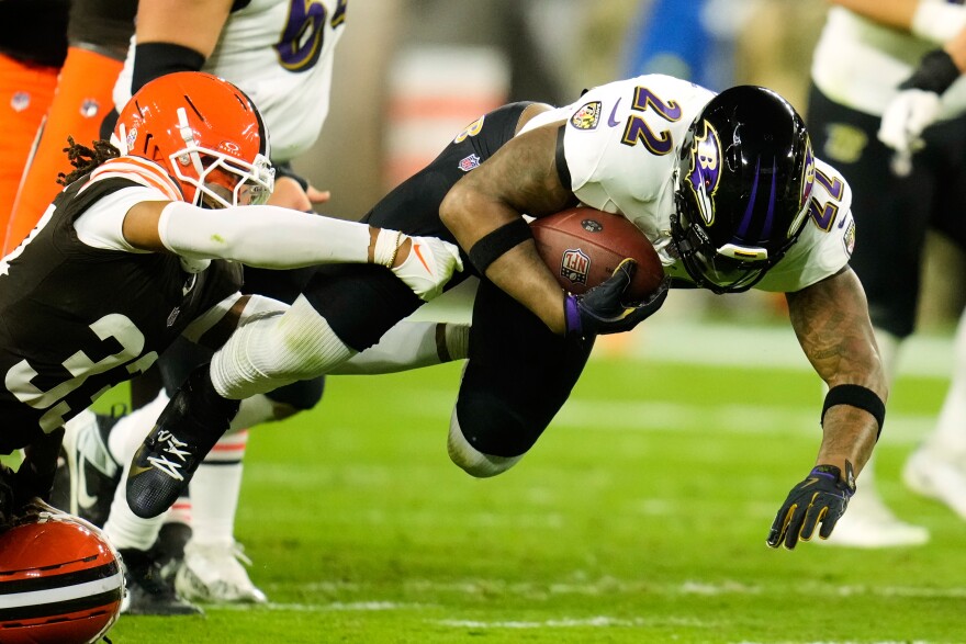 Baltimore Ravens running back Derrick Henry (22) is stopped by Cleveland Browns safety Ronnie Hickman (33) in the first half of an NFL football game in Cleveland, Sunday, Nov. 16, 2025. (AP Photo/Sue Ogrocki)