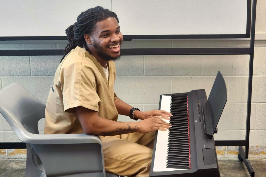 Koran Adams, 32, smiles during the last day of the piloted Melodies of Hope piano class at the Buzz Westfall Justice Center on May 19 in Clayton.