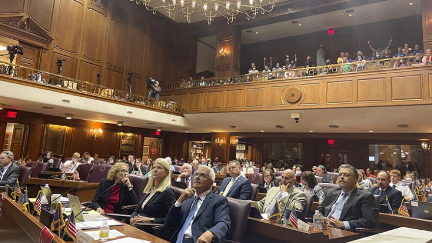 Indiana House committee members listen to testimony on its version of a Senate-approved abortion ban as listeners in an upstairs gallery of the Indiana House chamber in Indianapolis, Tuesday, Aug. 2, 2022, indicate their support.