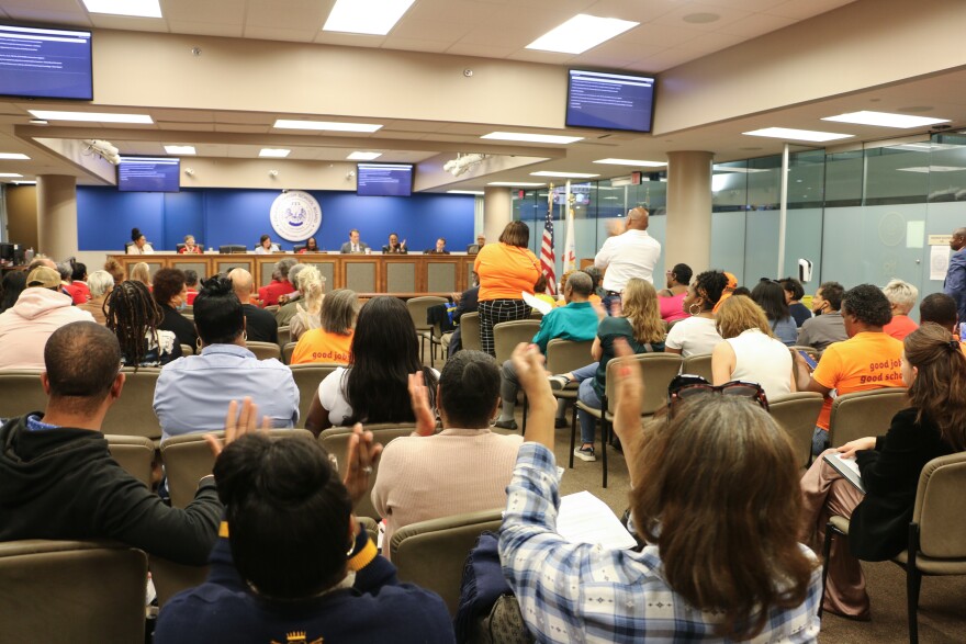 Community members applaud after a unanimous vote by New Orleans' school board to run a school directly next fall on Feb. 26, 2024.